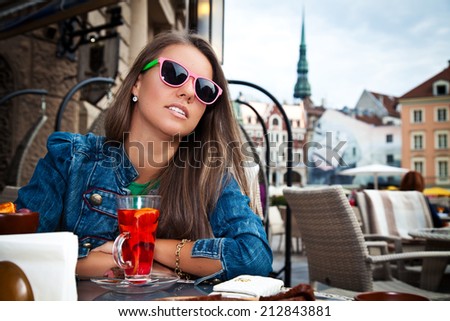 Beautiful woman in restaurant with hot tea and dessert.