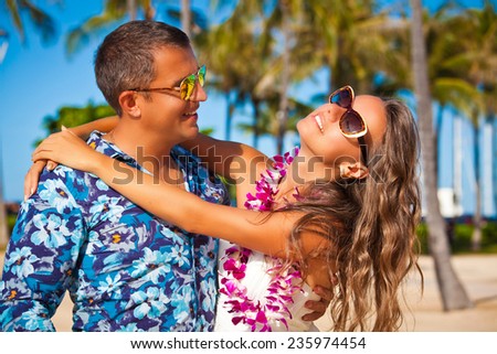 Shot of young couple enjoying beach getaway. Couple in love, summer luxury vacation in Hawaii. Travel holidays concept.
