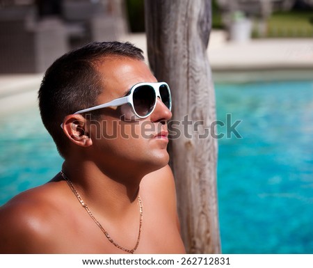 Portrait of a man relaxing at the luxury poolside, spending summer holidays. Living The Good Life.    Vacations And Tourism Concept.