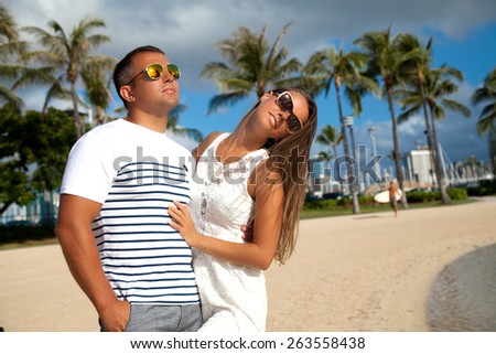 Happy couple spending romantic time together on Waikiki Beach, Oahu, Hawaii. Couple happy in love hugging each other. Summer luxury vacation in Hawaii.