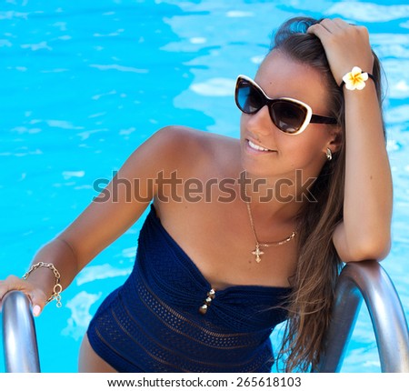 Shot of a teen girl enjoying a day at the luxury poolside, tanning. Girl at travel spa resort pool. Summer luxury vacation.