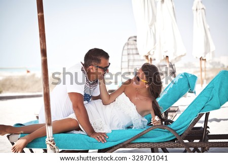 Happy couple in love on beach. Couple enjoying the perfect summer morning on tropical resort. Luxury vacation.