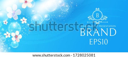 Soap foam with flowers on blue background. White transparent lather with bubbles. Fresh and clean product adverticing.