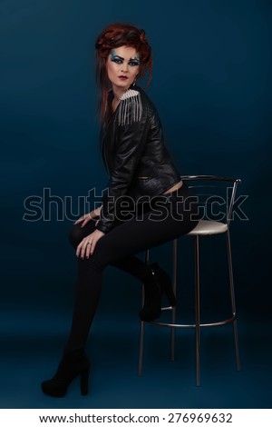 Fashion Dressed Sexy Girl Sitting on Chair. Full length Portrait. Beauty Woman in jacket and High Heels