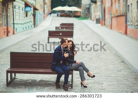 Couple kissing at the bench at alley.