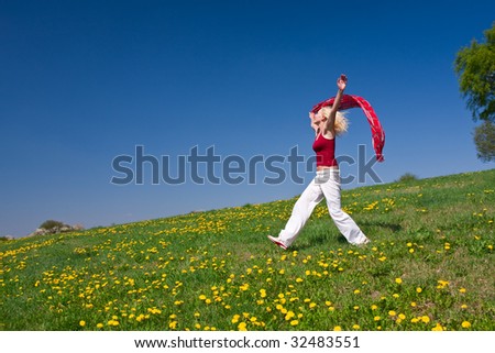 young woman with a red scarf on a meadow in the springtime