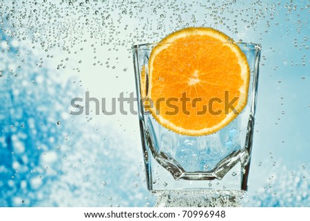 orange in the glass with mineral water