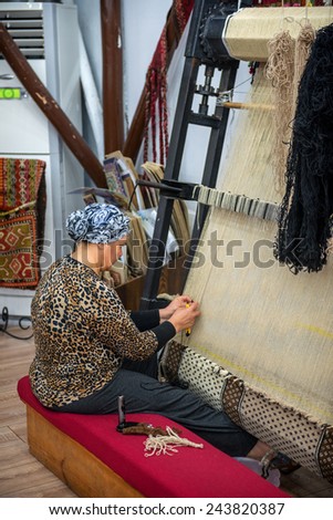 CAPPADOCIA - MAY 17 : Woman working at the manufacture of carpets, on May 17, 2013, in Cappadocia, Turkey. Turkish rugs are one of the main economic sectors of the country.