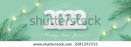 Happy New Year 2022 design. Light green background with paper cuted 2022, realistic pine branches and garland lights. Christmas poster, greeting card, banner, website header in modern minimal style
