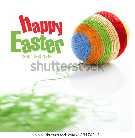 Easter egg covered with various colors wool. Bunch of green wool on first plan. Space for text