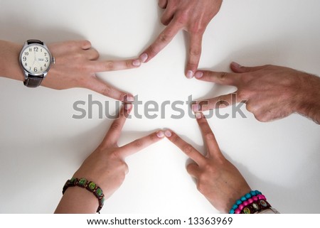 Five teenagers hands form a star. Two boy hands and three girl hands. Girls are wearing watch and bracelets