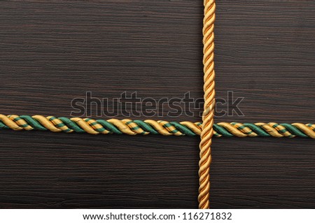colorful rope frame on dark wooden background