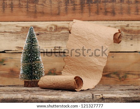 Little toy christmas tree with old paper scroll