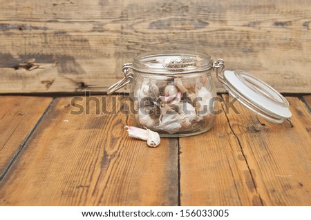 fresh garlic in glass jar  on old wooden table