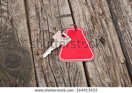 key with a blank label on an old wooden plank