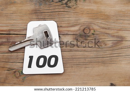 Hotel suite key with room number 100 on wood table