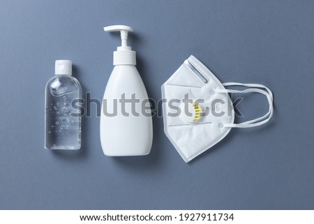 Protective, white face mask N 95, building respirator, sanitizer gel, soap on gray background, close-up, flatly. Hygiene concept, personal protectional gear, prevention of spread of infections. Stock foto © 