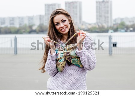 Portrait of happy beautiful smiling woman with bag on urban background