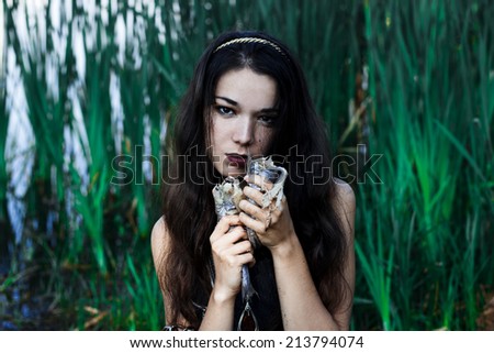 Angry dangerous mermaid eating fish