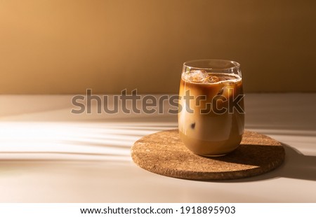 Glass of a iced coffee with cream milk. Cold brew coffee drink with ice. Early morning sun light. Copy space. Stock foto © 