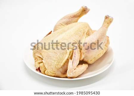 Raw fresh chicken carcass fresh meat lies on a white plate on a white background isolated. Concept of poultry meat preparation, dietary meat
