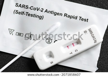 Positive SARS‑CoV‑2, Covid-19 antigen test kit, one step coronavirus antigen rapid test, saliva swab, 1 test box with imagine of lungs, close up Stok fotoğraf © 