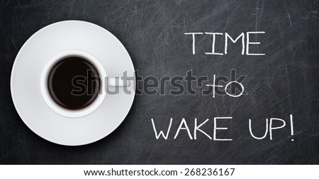 TIME to WAKE UP text and cup of coffee on blackboard
