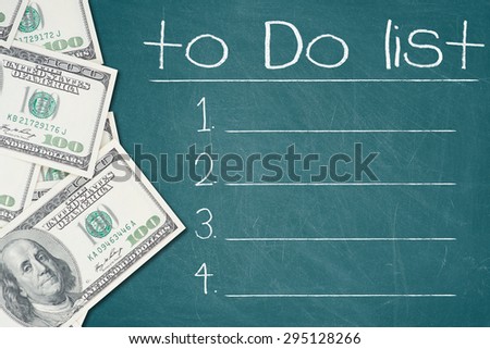 TO DO LIST text written on a green chalkboard with a number of one hundred US dollar notes