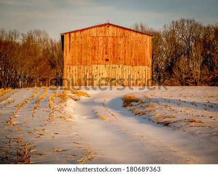 Winter Barn at dusk in south-central Kentucky golden snow trail country rural farm homestead tree red glisten sky wooden sunset shadow outdoor cold ranch clouds