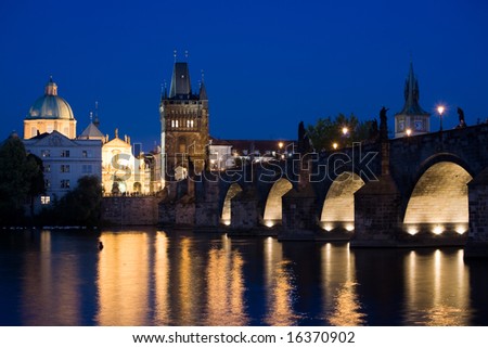 Night view to Charles bridge and Old Town church towers via Vltava river.