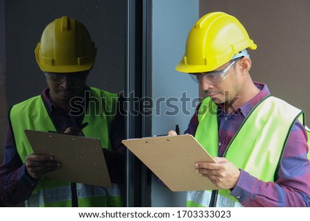 Worker, inspector, engineer or auditor is checking building structure around window with checklist clipboard in hand. Inspection, quality checking and audit concept Stok fotoğraf © 