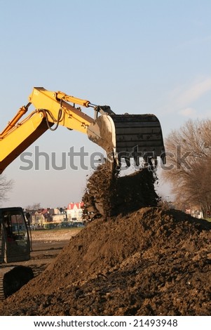 Earth remover with brown earth pile under shovel