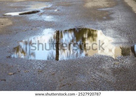 Similar – Foto Bild Pfützen auf einer Landstraße nach Regenfällen. Schwarz und weiß düstere Landschaft Szene