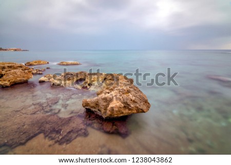 Long exposure in Antalya, with brown rocky seaside and cloudy weather. Longexposure time 4 minutes Stok fotoğraf © 