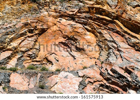 Corroded solid rock layers with a circular rugged and repetitive pattern.