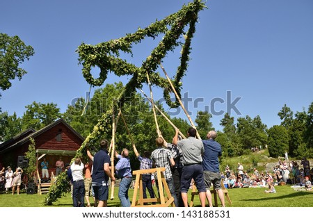 TORSTUNA,SWEDEN - JUNE 21: Unidentified people take care of maypole in midsummer event. The official name is midsummer event and organization are hembygd Torstuna on June 21, 2013 in Torstuna Sweden