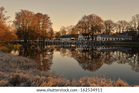 Lakeside cottages between autumn and winter at sunrise