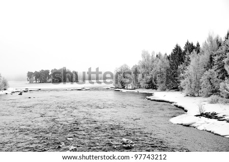 Black and white picture of frosty river landscape