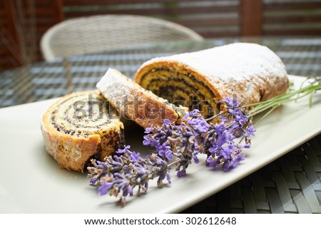 poppy seed roll cake dessert on a plate with lavender flowers in a street coffee