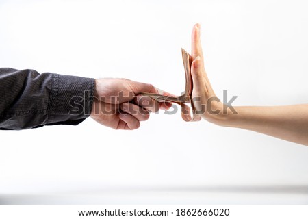 A man's hand in a black shirt gives a stack of money to a woman's hand, which refuses. Side view. White background. The concept of the world anti-corruption day Foto stock © 