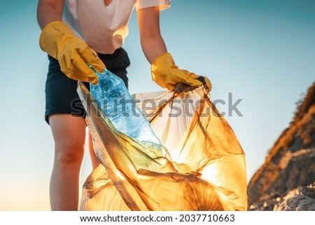 Similar – Image, Stock Photo Activist young woman picking up trash with garbage tongs backwards to camera.Forest background with sunset.New generation.Volunteering cleaning forests and fields.Environment,recycle,awareness,renewable sources,ecology