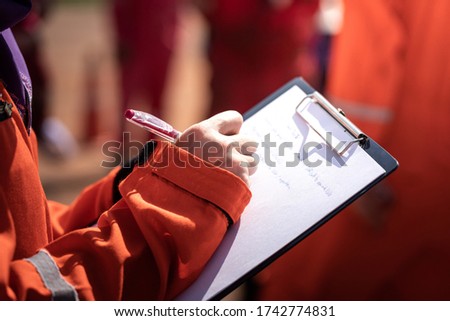 Action of safety officer or supervisor is taking note during operation audit in oil field activity, Close-up and selective focus at people's hand. Stock foto © 