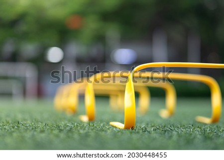 A set of obstacle for leg strength and speed practice, placed on football training turf ground. Sport equipment photo, close up and selective focus on a part of the object. 商業照片 © 