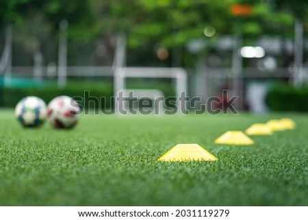 Obstacle cone for speed and moving training on artificial turf ground for football training. Sport equipment object photo. Selectived focus at the front cone. 商業照片 © 