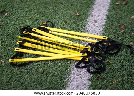 A speed and agility ladder, football training gear, which is placed on soccer turf pitch. Sport training equipment object photo. Selective focus at the equipment part. 商業照片 © 