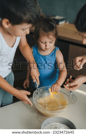 Similar – Image, Stock Photo Cheerful siblings mixing dough together in kitchen