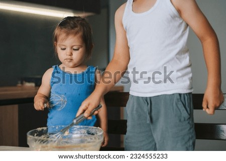 Similar – Image, Stock Photo Cheerful siblings mixing dough together in kitchen