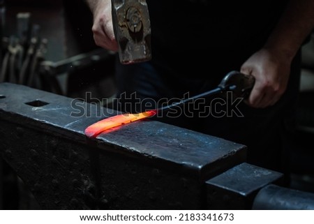 Close up view of heated metal and anvil. Blacksmith in the production process of other metal products handmade in the forge. Metalworker forging metal with a hammer into knife. Metal craft industry. Stock fotó © 