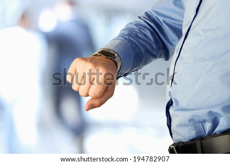 businessman checking time on his watch at office