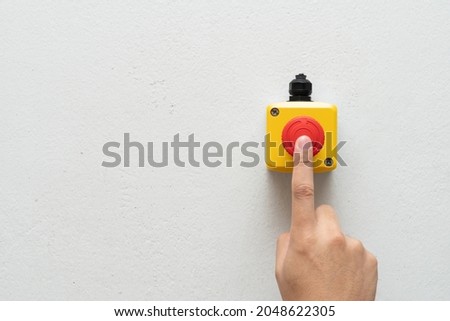 Stop Red Button and the Hand of Worker About to Press it. emergency stop button. Big Red emergency button or stop button for manual pressing.